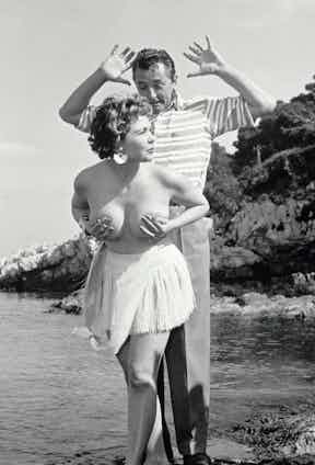 British actress Simone Silva photographed topless with Robert Mitchum on the Lérins Islands.
