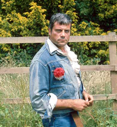 Wearing a double denim ensemble over a white ruffled poet shirt and finished with a red carnation, 1980. Photo by Mike Kenny/REX/Shutterstock.