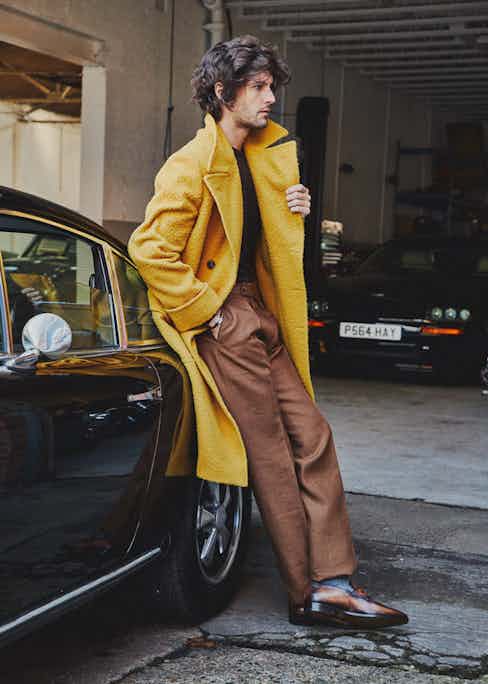 Mustard wool Casentino ulster coat, Rubinacci; Brown cashmere tobacco pleated front linen trousers, Huntsman; Chocolate crew neck cashmere sweater, Anderson & Sheppard; Grey merino wool socks, Pantherella; Brown Andy Démesure leather loafer, Berluti.