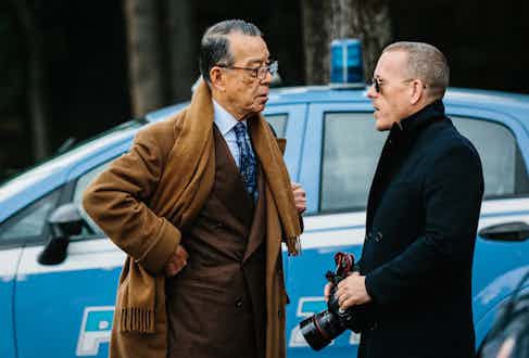 Yukio Akamine wears a double-breasted chocolate flannel suit with a light blue poplin shirt as he speaks with the master of street-style photography, Schott Schuman.