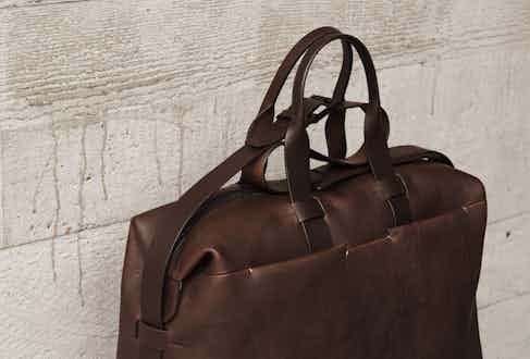 The Weekender is the ideal travelling bag with ample space for clothes and accessories. It features two external front pockets, an adjustable and detachable shoulder strap, shorter hand straps, a cotton lining, internal pockets and a robust silver zip fastening across the top.