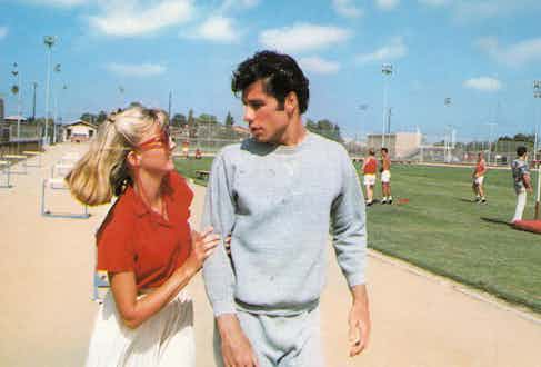 John Travolta in Grease wearing the classic two-piece athletic suit.