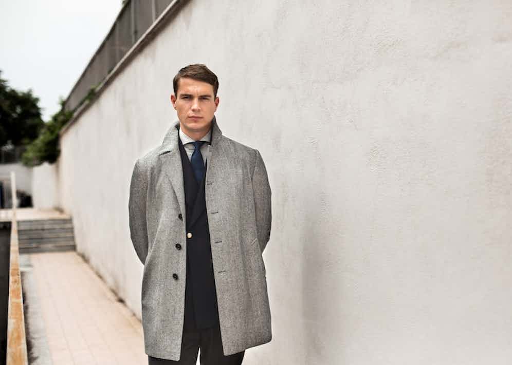 Grey wool herringbone overcoat with a double-breasted navy blazer from De Petrillo. Photography by Shaun Darwood.