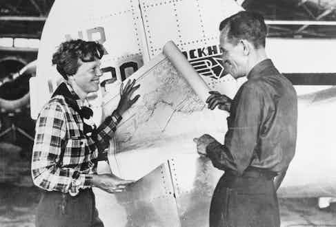 Pilot Amelia Earhart and her navigator, Fred Noonan, with a map of the Pacific that shows the planned route of their last flight.