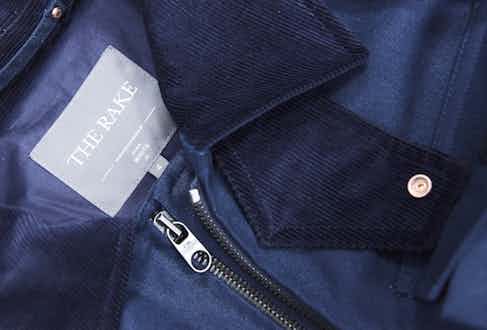 A dual-branded logo alongside the complementing tones of navy cotton canvas and needle corduroy.