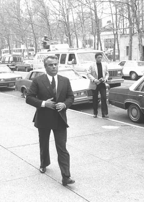 Gotti buttoning his double-breasted suit as he arrives at Brooklyn Federal Court, 1986 (Photo by NY Daily News Archive via Getty Images)