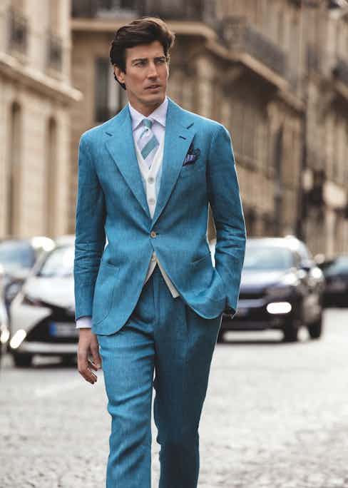 Riviera: Light blue sport jacket; light blue sport trousers; white sport shirt with one-piece collar; light blue knitted cotton waistcoat; turquoise and white club silk tie; blue and purple floral pocket-square; beige suede loafers.
