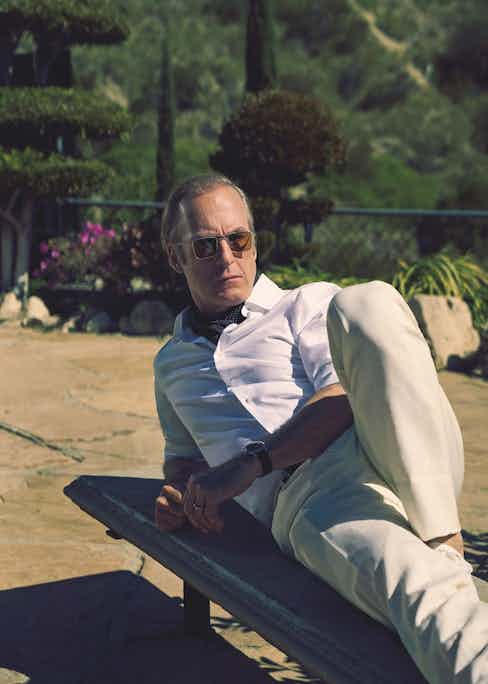 Ivory linen jacket, matching trousers and white cotton shirt, Brioni; white sneakers, Dolce & Gabbana; sunglasses, Jacques Marie Mage. Watch and wedding ring, property of Bob Odenkirk. Black spot silk scarf and black belt, stylist’s own.